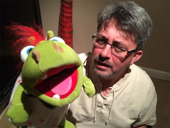 The green frog puppet with its mouth wide open